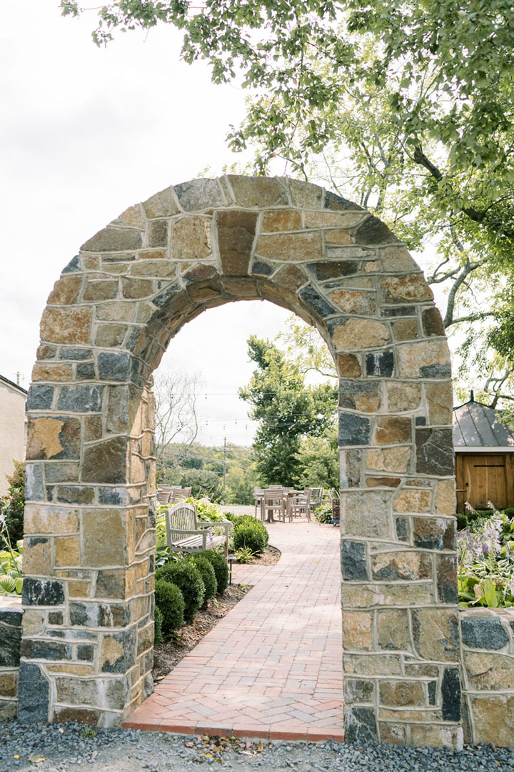 A stone archway leading inside Fleetwood Farm Winery, an outdoor winery in Loudoun County, Virginia.