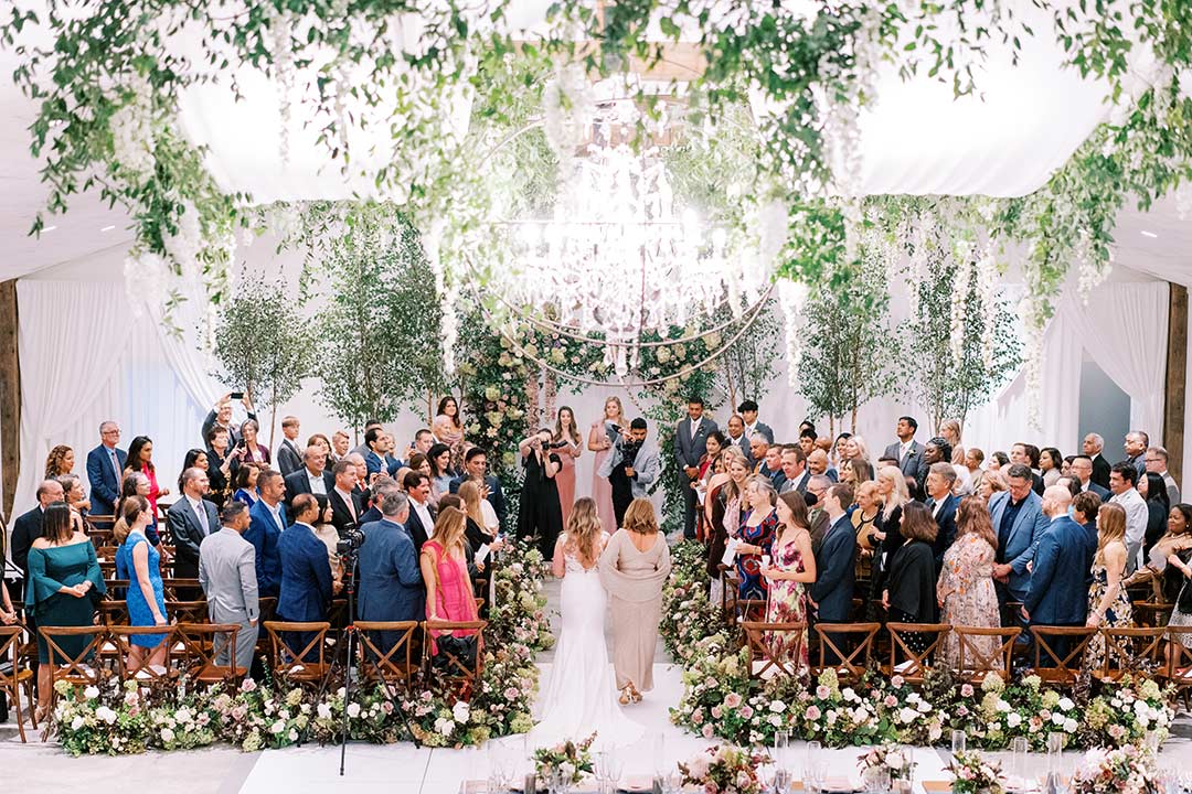 A wedding party standing as the bride is walked down the aisle by her mother at a winery wedding venue in Loudoun County, Virginia.