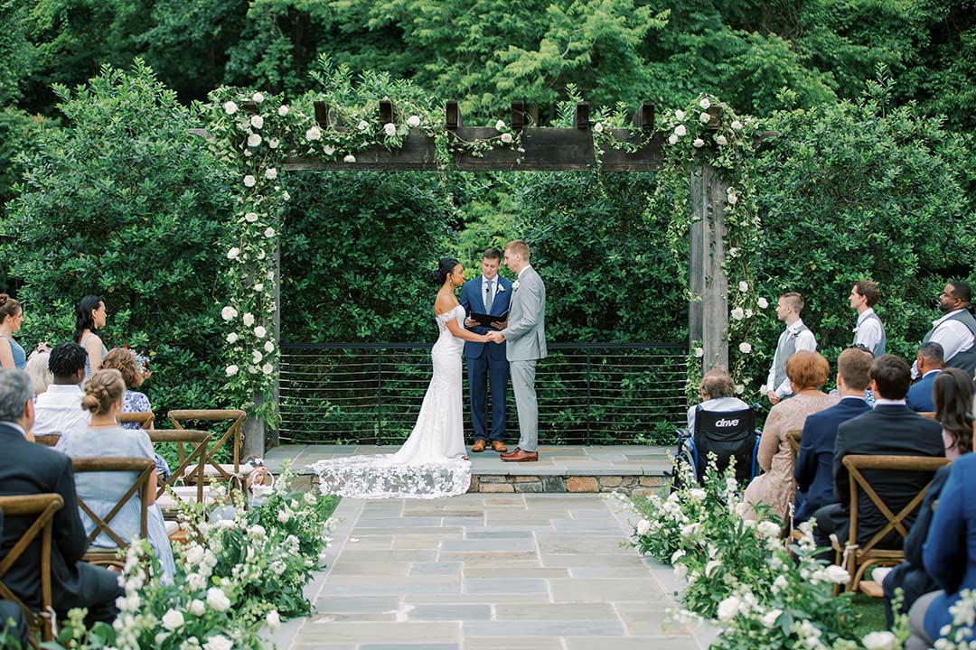 A bride and groom giving their vows during a wedding ceremony in Fleetwood Farm Winery's wedding ceremony garden.