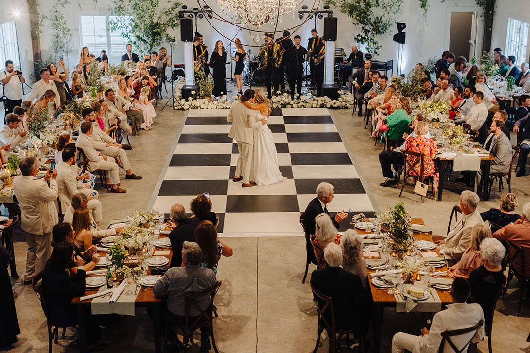 A bride and groom sharing a dance on a checkered dance floor at a wedding reception inside of Fleetwood Farm Winery, a winery wedding venue in Leesburg, VA.