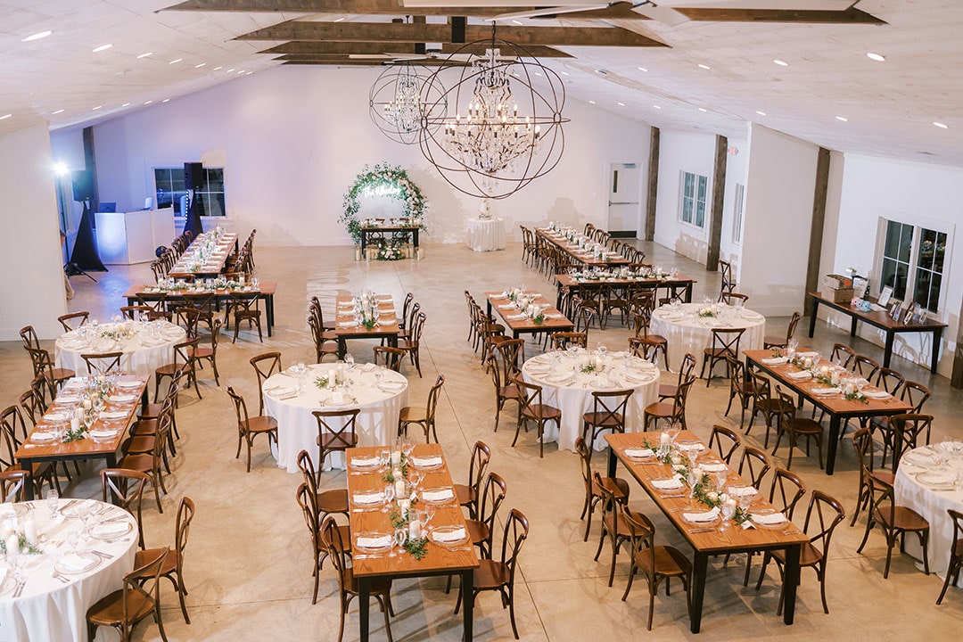 An overhead view of finely decorated tables, prepared for a wedding reception inside of Fleetwood Farm Winery's private event space in Leesburg, Virginia.