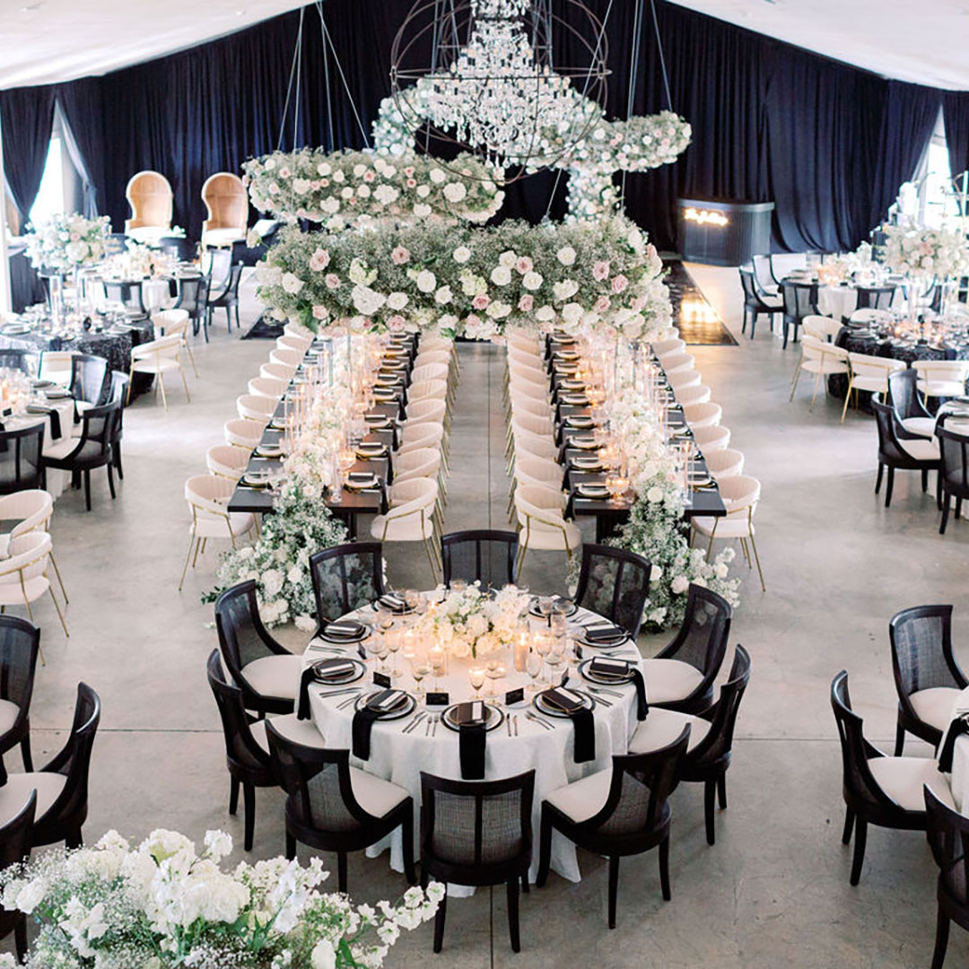 A wedding reception venue decorated with white flowers and tables set for a wedding party.