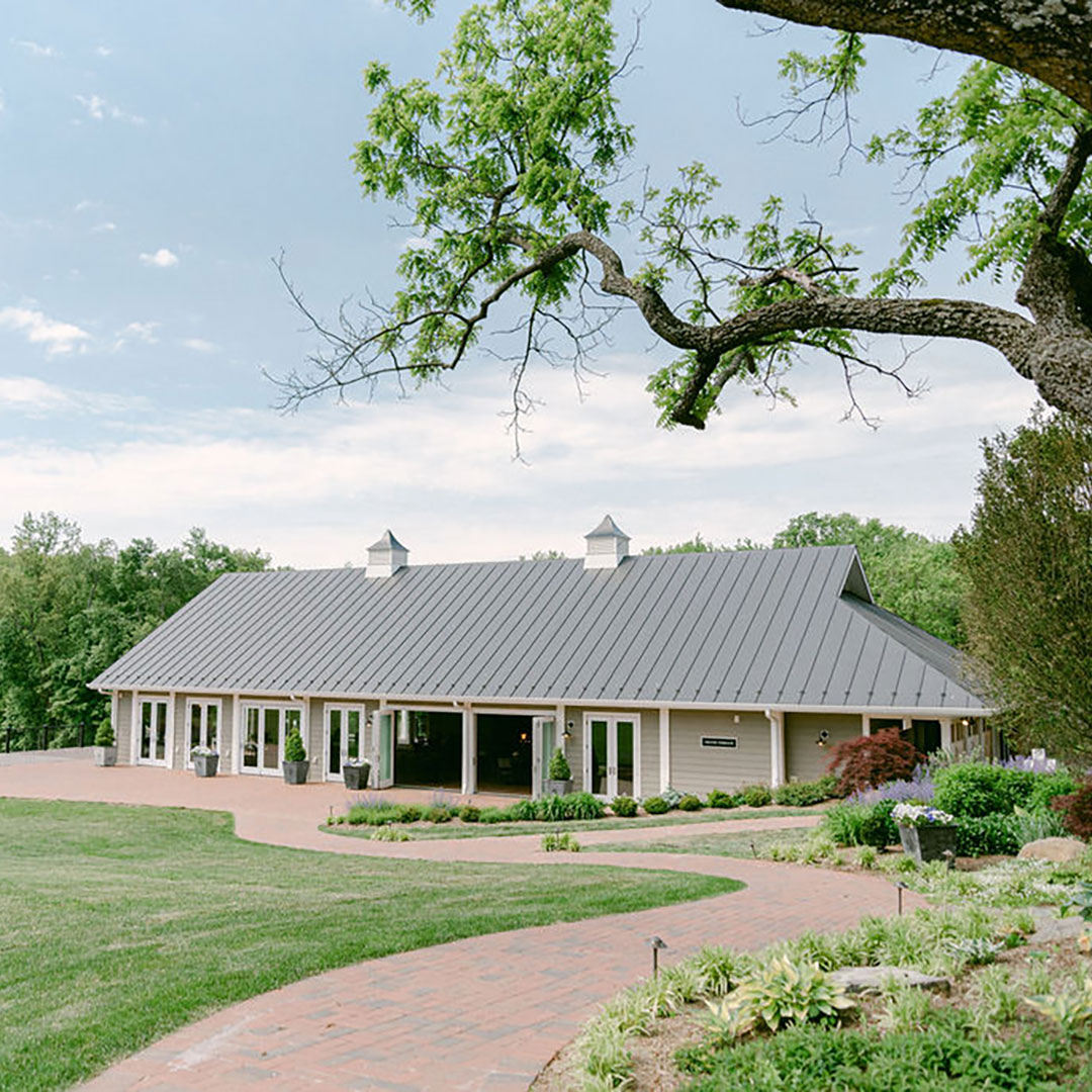 A brick walkway leading to an indoor outdoor event space overlooking the vineyards at a top Virginia winery with food.