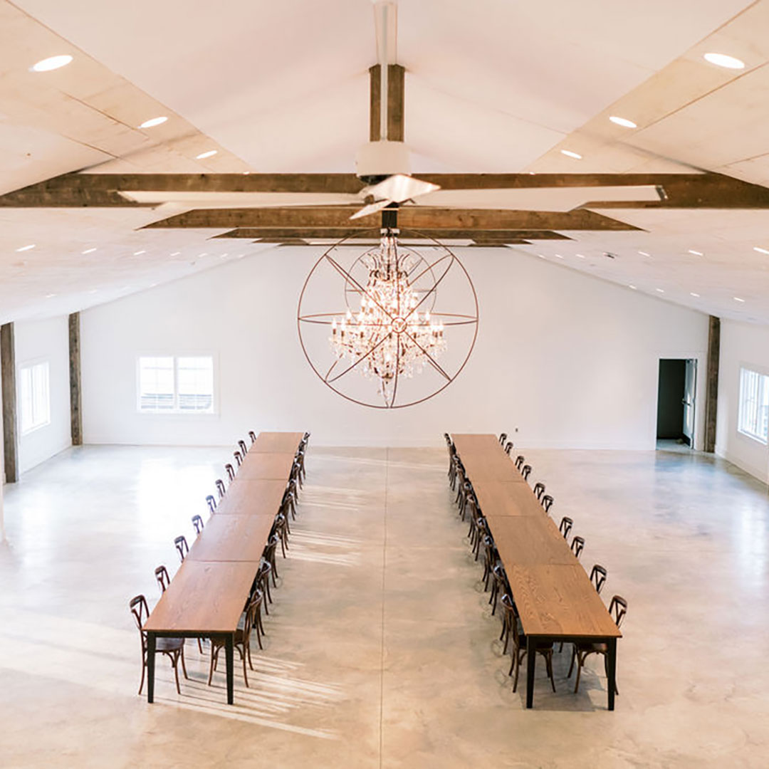 A massive indoor event venue in Leesburg Virginia, equipped with a chandelier and two long tables.