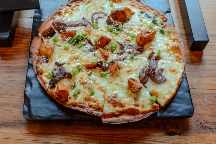 A veggie flatbread on a wooden table at a Virginia winery with food near me.