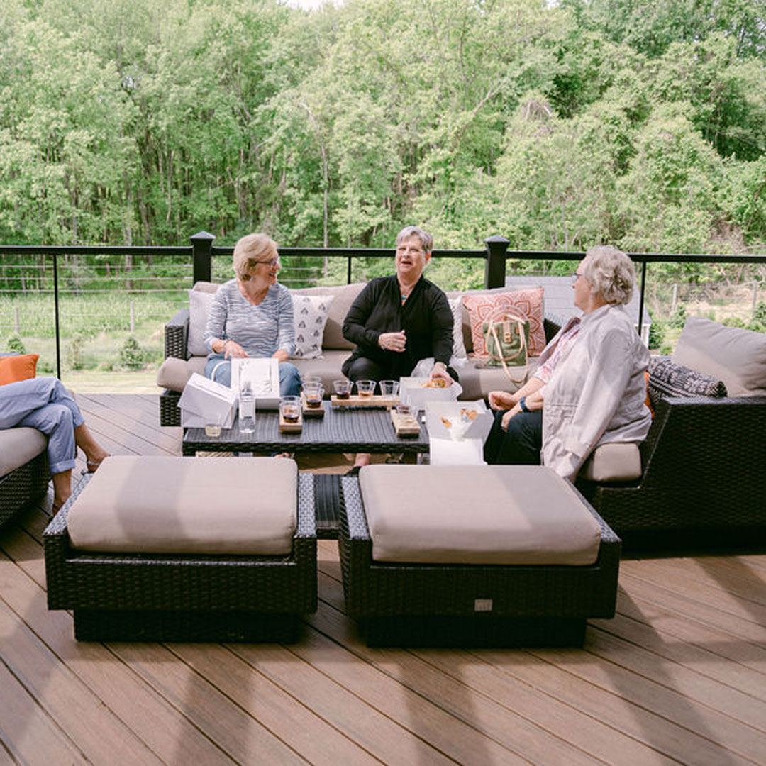 Three women seated at an outdoor patio area at an outdoor winery with food near Ashburn, Virginia.