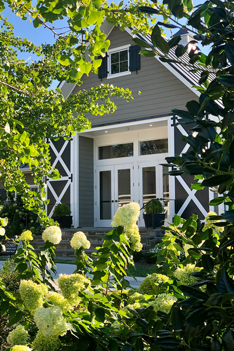 An exterior view of Fleetwood Farm Winery's front entrance from hydrangea plants on the property.